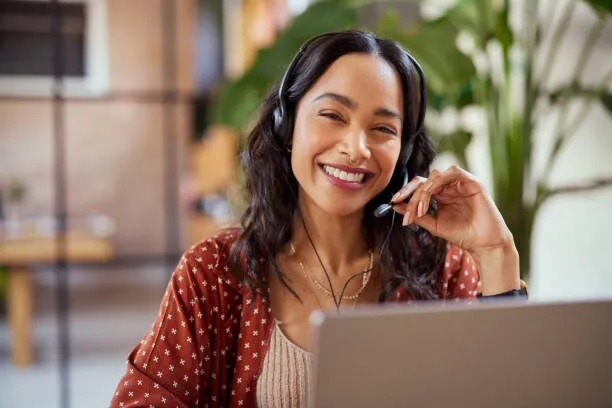A support agent smiling while helping a customer